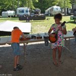 Young pickers checking out the instrument petting zoo at the 2016 Milan Bluegrass Festival - photo © Bill Warren