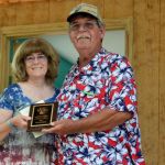 Judy Assenmacher accepts the SMBMA Hall of Honor induction for her father, Nick Mladjan, from Bill Warren at the 2016 Milan Bluegrass Festival