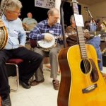 Joe Deetz and George Gruhn checking out banjos behind Carter Stanley's 1941 D-28 Martin guitar at Banjothon 2013 - photo © Dean Hoffmeyer