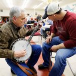 Jerry Keys shows Brandon Henson (right) a Scruggs lick on the Wille Bivens RB-3 wreath at Banjothon 2013 - photo © Dean Hoffmeyer