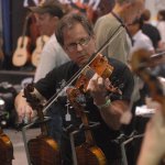 Trying out fiddles in the exhibit hall during Fan Fest 2012 - photo by Dan Loftin