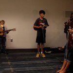 Danny Clark explains to the bluegrass kids that this is their room to hang and jam in all week, and that there is pizza there for them to eat - so party on! - photo by Tara Linhardt