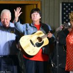 MC Sherry Boyd (right) shows of the autographed guitar to be given away at Palatka Bluegrass Festival, February 2014 - photo © Bill Warren