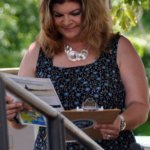 MC Cindy Baucom peruses the schedule at Red, White & Bluegrass (July 4, 2013) - photo by Bill Warren