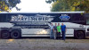 Gary Brewer & The Kentucky Ramblers pose with their newly-wrapped MCI bus