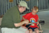 Young mandolinist in the making at the SMBGMA instrument petting zoo during the 2016 Charlotte Bluegrass Festival - photo © Bill Warren